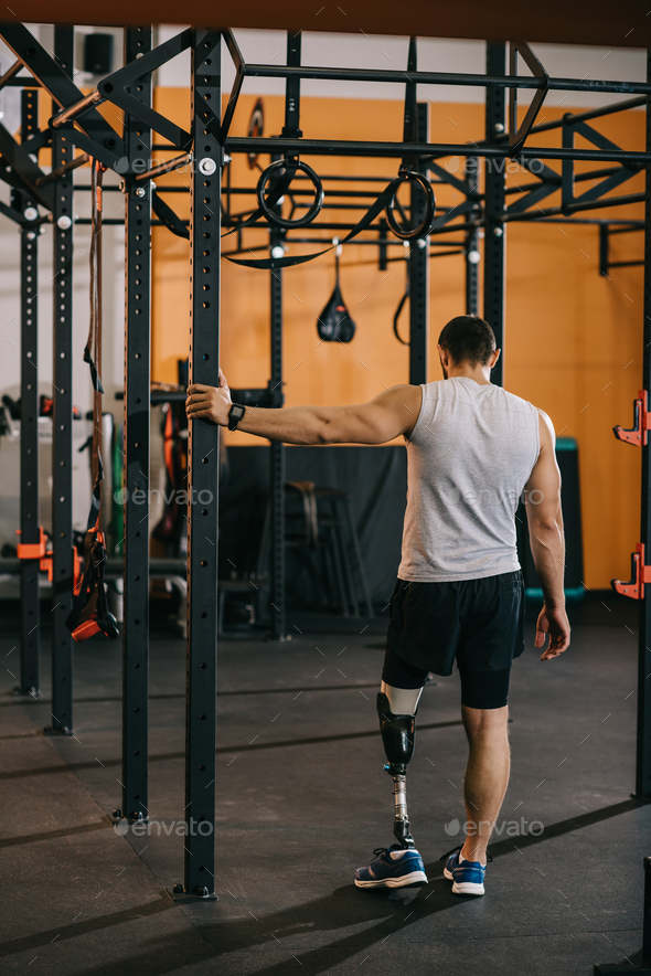 rear view of young sportsman with artificial leg standing near