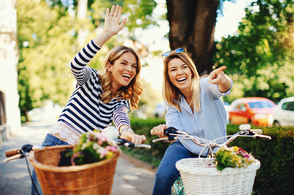 Two young women tourists exploring the city on bicycles Stock Photo by ...