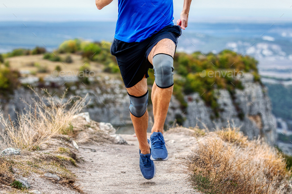 legs runner man in knee pads running mountain trail, protection knee sleeve