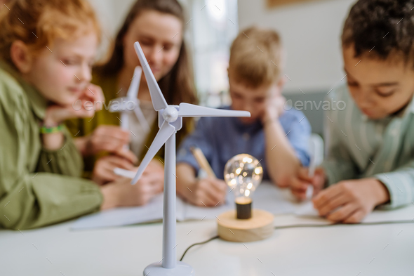 Young Teacher With Model Of Wind Turbine Learning Pupils About Wind ...