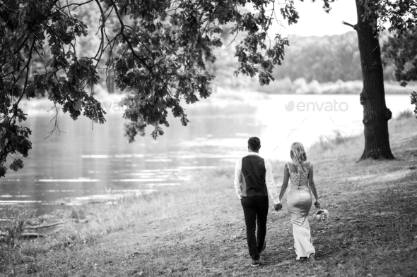 Stylish couple of happy newlyweds posing in the park on their wedding ...