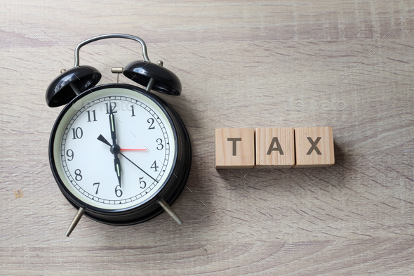 The word tax on wooden cubes with an alarm clock