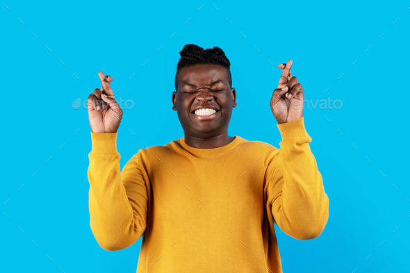 Making Wish. Portrait Of Cheerful Black Man Keeping His Fingers Crossed - Stock Photo - Images