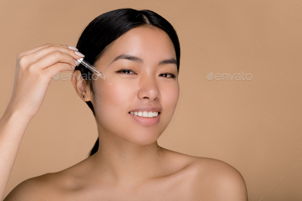Skin care concept. Pretty chinese beauty girl with perfect skin and nude shoulders, care face skin