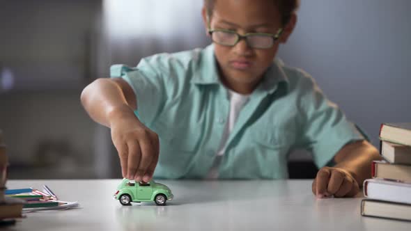 Preschooler Boy Playing with Toy Car, Dreaming About Real Auto and Traveling alt