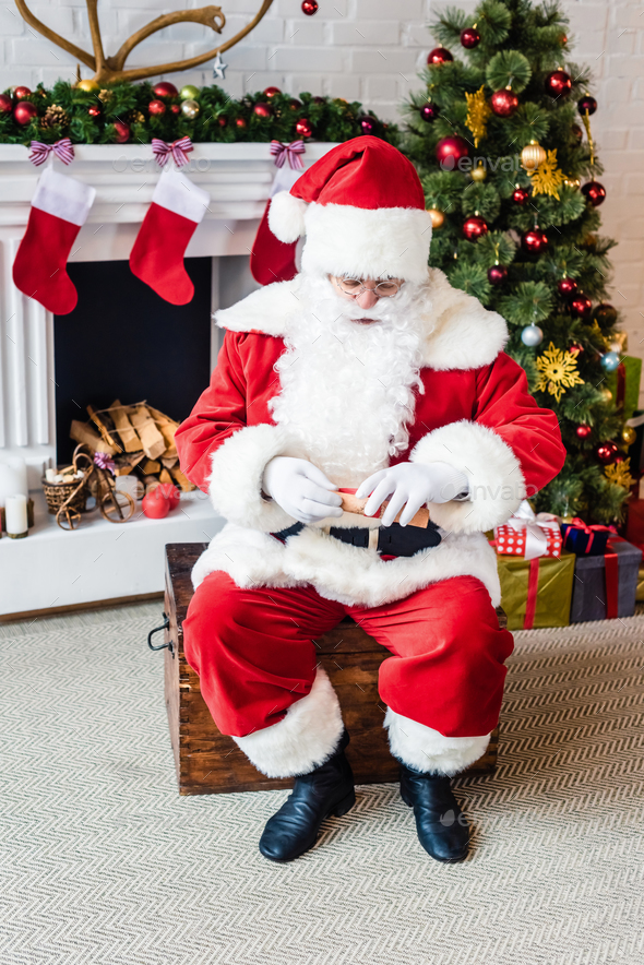 high angle view of santa claus holding rolled parchment with wish list
