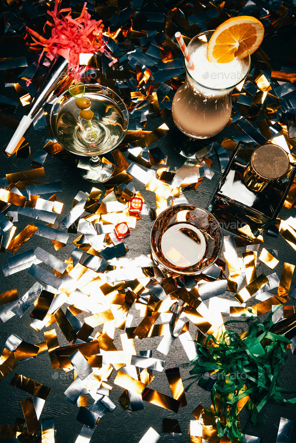 View From Above Of Alcoholic Cocktails Whiskey And Party Horns On Table Covered By Golden 