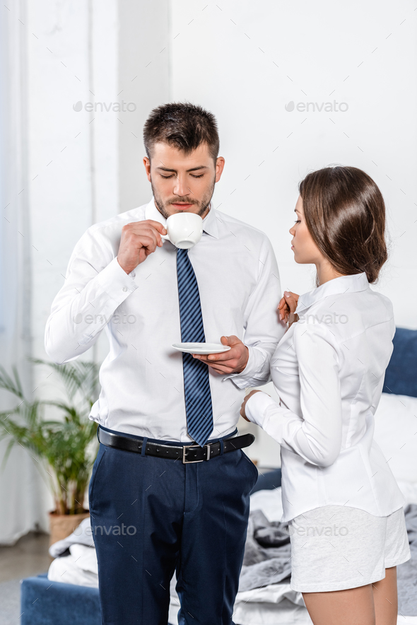 girlfriend waiting while boyfriend drinking coffee in morning at home, social role concept
