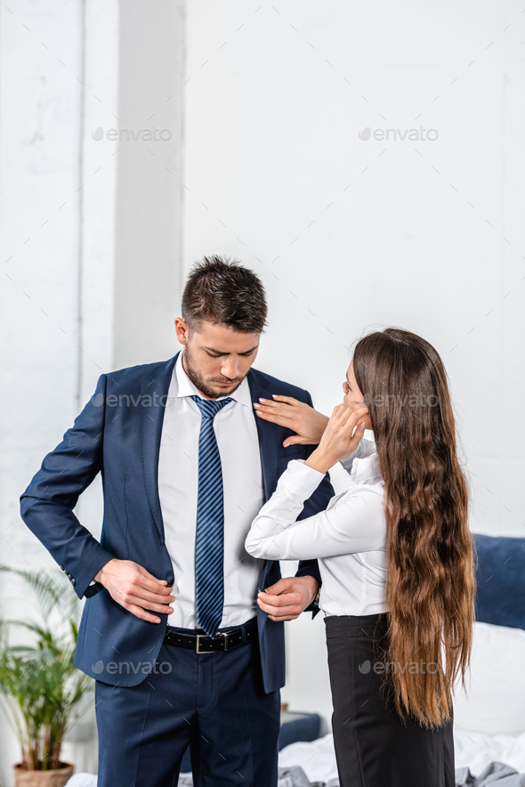 girlfriend fixing boyfriend jacket before work, social role concept