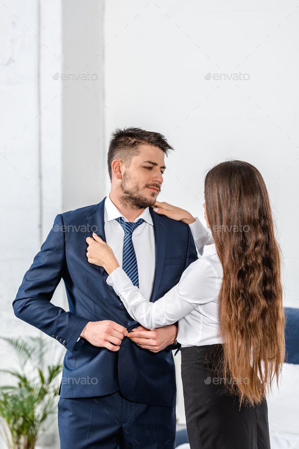 girlfriend fixing boyfriend jacket before work, gender stereotypes concept