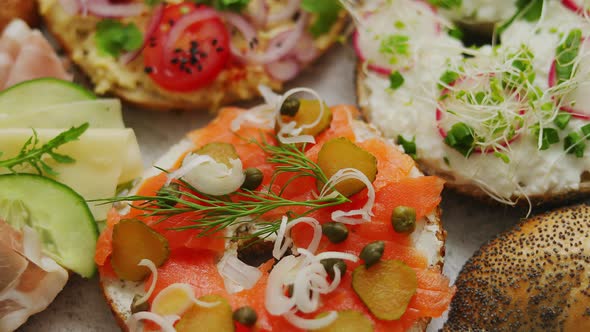 Assortment of Different Kinds Toppings Homemade Bagels Sandwiches with Sesame and Poppy Seeds alt