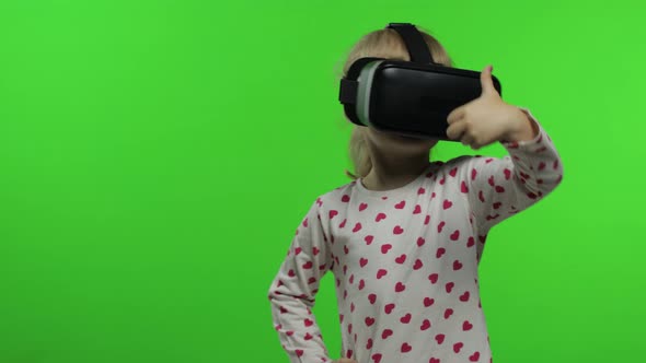 Child Girl Using VR Helmet To Play Simulation Game App. Watch Virtual Reality 3d Video. Chroma Key alt