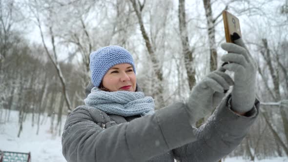 Smiling Adult Woman Posing and Taking a Selfie on the Phone in Winter Park alt