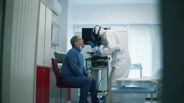 COVID 19, Virus, Coronavirus, Epidemic Concept. Hospital Worker Is Taking a Mouth Swab of an Elderly alt