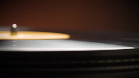 Dropping Stylus Needle On Vinyl Record Playing With Disc Rotating Close Up. Old dusty turntable. alt