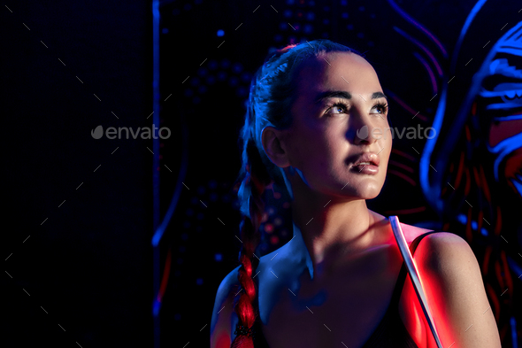 A young woman in fashionable youth club clothes in neon light.Red,purple,blue neon lights. Nightlife