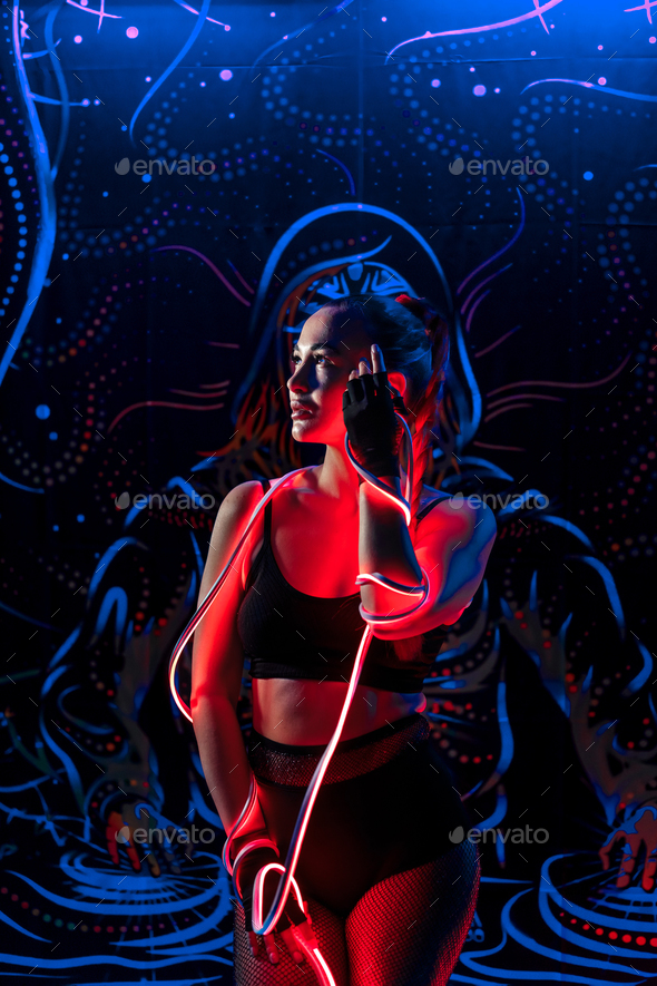 A young woman in fashionable youth club clothes in neon light.Red,purple,blue neon lights. Nightlife