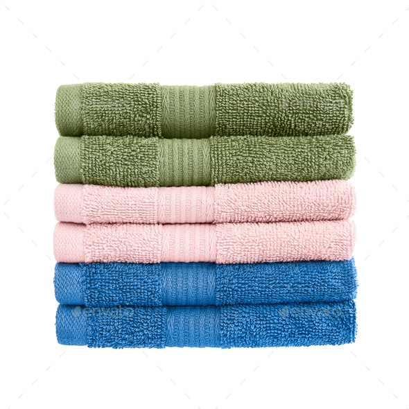 Green, pink and blue bath towels in stack isolated over white