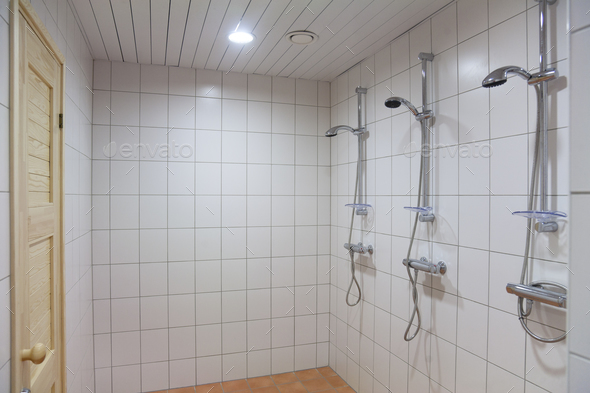 A large shower room, tiled in white tiles,with three showers. Changing room and a wet room.