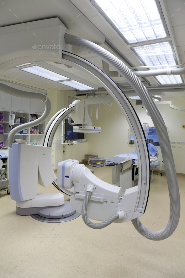 A modern hospital room, a large portable mobile scanning machine with curved shaped arms