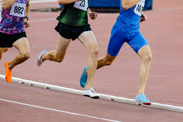 Three Runners Athletes On Middle Distance Running Together In Track