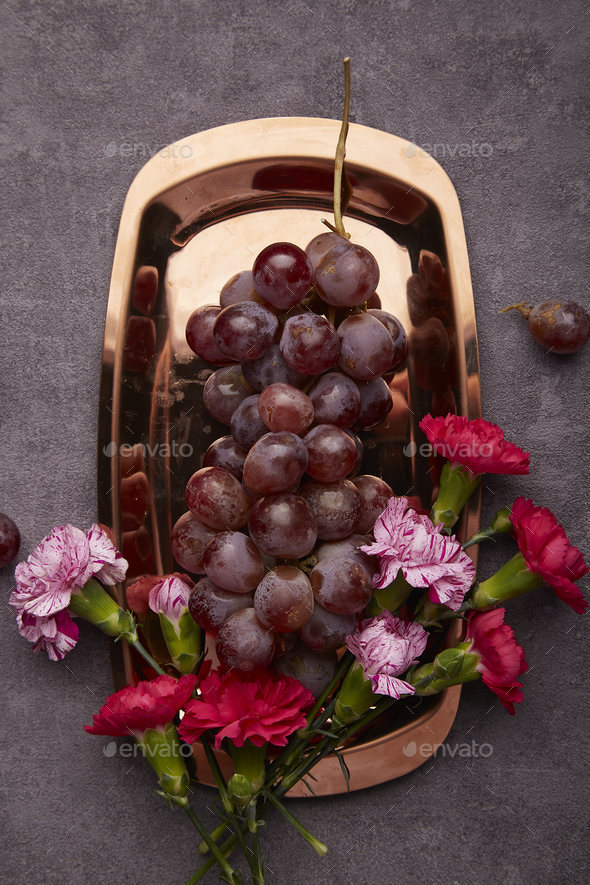 Aesthetic grapes with aster flower on the golden tray. Summertime ...