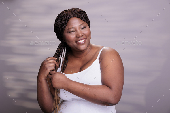 Body positive woman braiding long hair with ombre effect