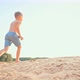 A Cute Boy Runs Along the Beach Sand Along the Pond on a Sunny Summer Day - VideoHive Item for Sale