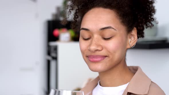 Satisfied African American Girl with Curly Hair Takes Care of Her Health Drinks Clean Water with alt