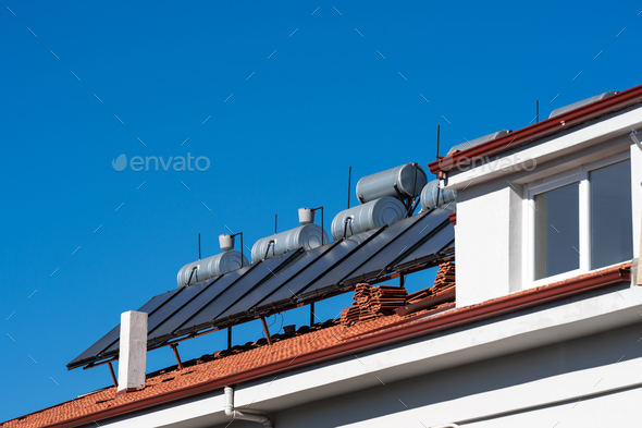 Roof with solar panels and water tanks. House roof with solar panels and water tanks Space for text.