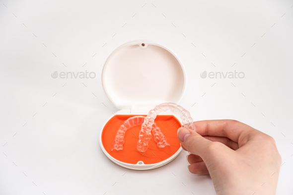 Transparent aligners retainers in a storage case. Invisible braces. Clear teeth straighteners