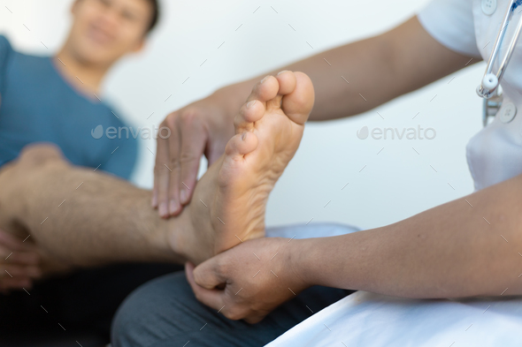 The doctor is diagnosing pain in the patient\'s ankle.
