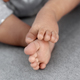 Closeup of infant baby feet on grey blanket as a background, babyhood and childhood concept - PhotoDune Item for Sale