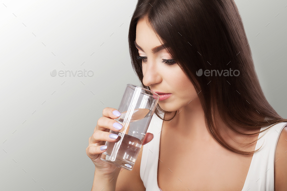 Happy young beautiful woman drinking water.