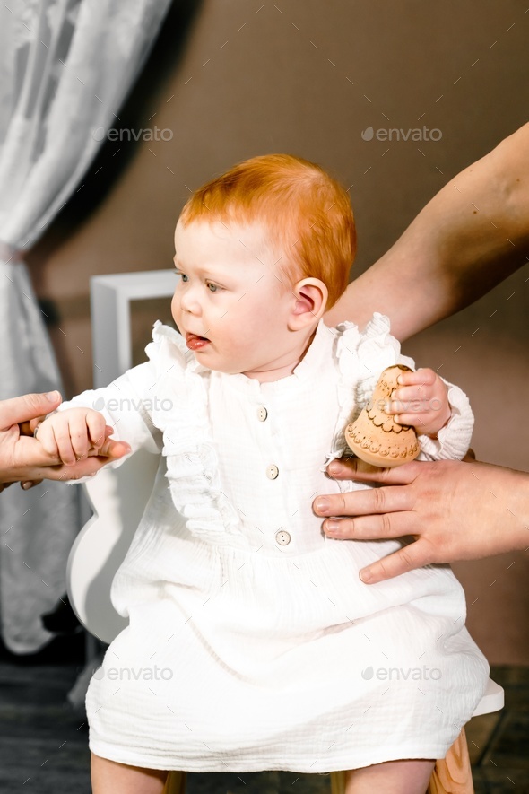 Little redhead baby girl celebrates first birthday anniversary. 1 year family party Professional
