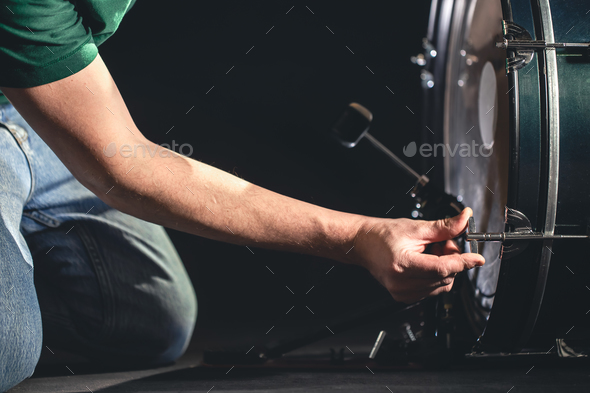 Bass drum and drummer, musical instrument on black background.