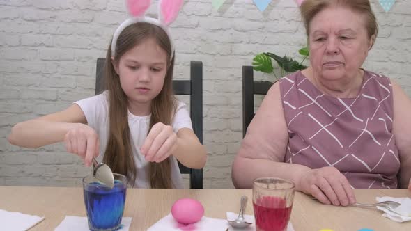 Child Girl with Grandmother Preparing for Easter Day at Home alt