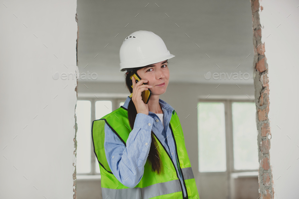 foreman woman consults clients on mobile phone. Inspector or Safety Supervisor in construction site
