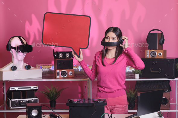 Smiling artist holding red speech bubble advertising text messages cardboard in studio