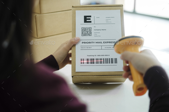 Female online business owner scan shipping label on parcel.