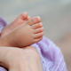 Newborn baby feet in mother&#39;s hand at natural light, tiny toes of infant girl - PhotoDune Item for Sale