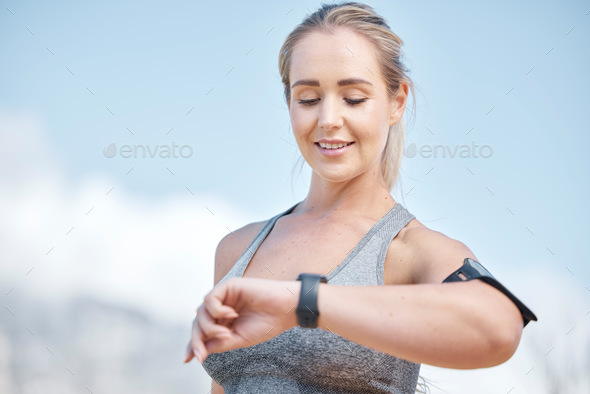 Fitness, woman and smart watch checking time, tracking performance or monitoring exercise in nature
