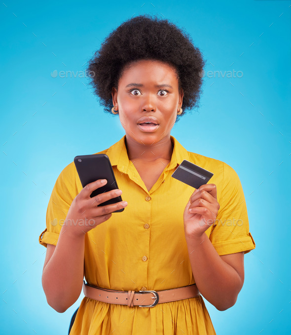 Black woman, phone and credit card with shock, portrait and wow face in studio by blue background.