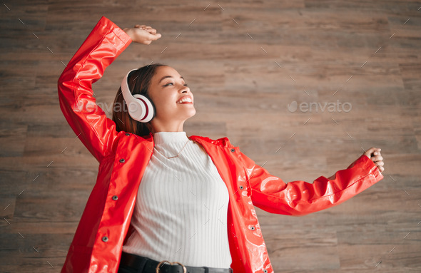 Woman, happiness and dancing with music headphones isolated on a wood background. Freedom, dance an