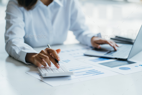 Female businesswoman readind financial report analyzing statistics pointing at pie chart working at