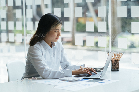 Female businesswoman readind financial report analyzing statistics pointing at pie chart working at