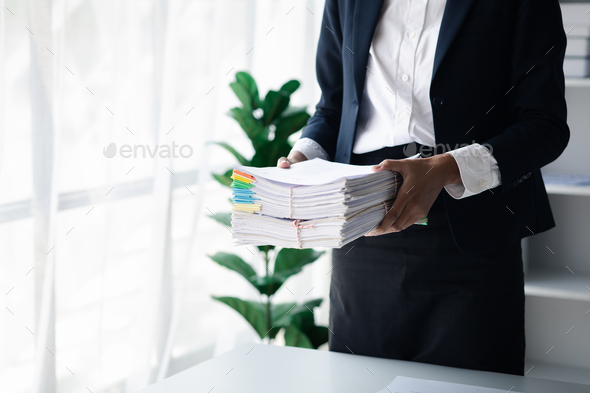 Businessman holding a lot of documents, corporate financial documents.