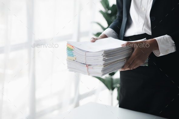 Businessman holding a lot of documents, corporate financial documents.