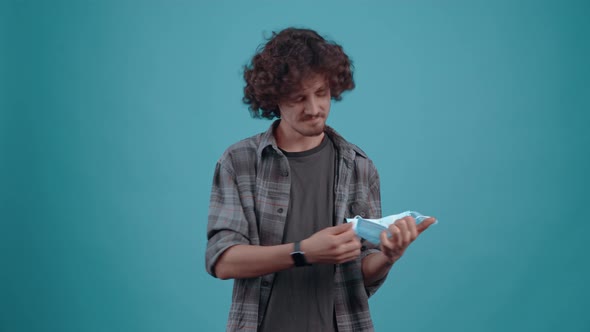 The Charismatic and Optimistic Young Man Takes Off His Mask Raises His Hands with Joy and Smiles alt