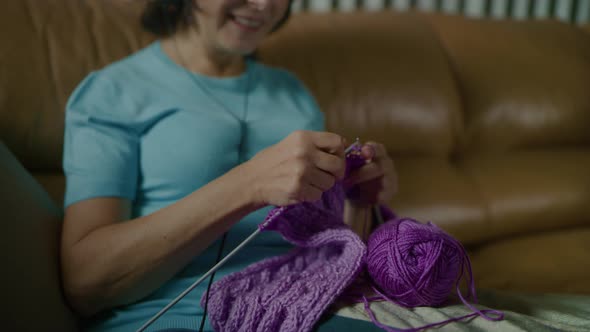 Woman Knits Scarf with Spokes Listens to Music with Headphones and Dances